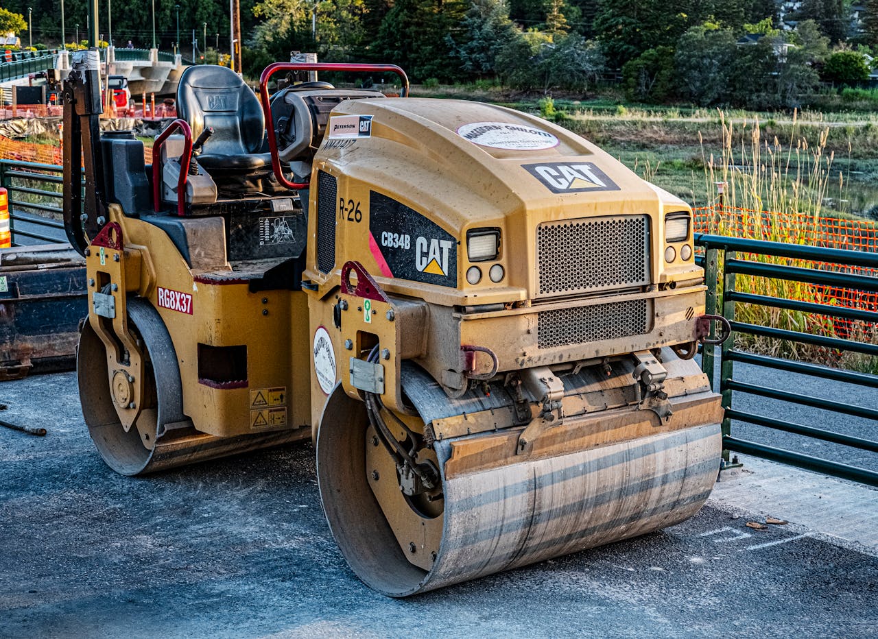 our-story A CAT road roller on an outdoor construction site, perfect for industrial imagery.